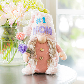 A stuffed gnome holding flowers and a #1 mom hat