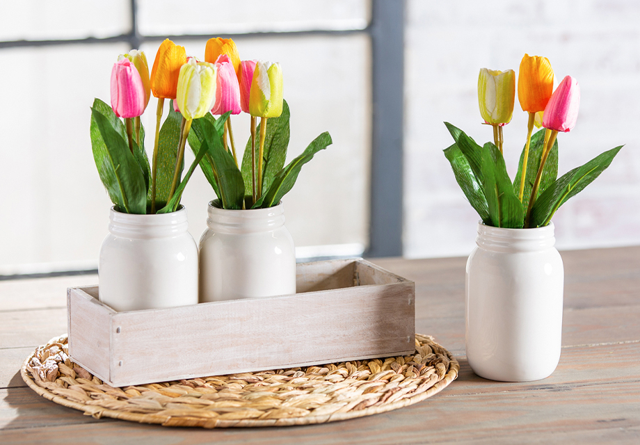 a group of painted glass jar vases with flowers in them