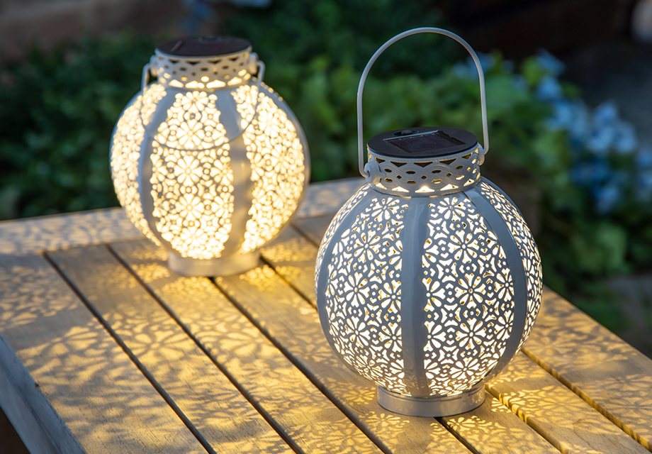two pattern covered lanterns on a table 