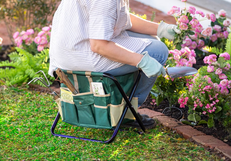 a person sitting in a chair with a garden tool and flowers